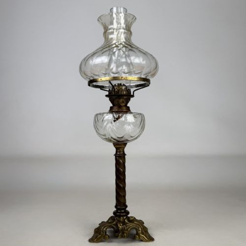 fig 1. A 19th-century brass oil lamp featuring a cast footed base, a spiral twisted column, a clear swirled glass reservoir, and a matching swirled glass shade.