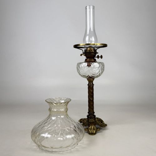fig 3. A 19th-century brass oil lamp featuring a cast footed base, a spiral twisted column, a clear swirled glass reservoir, and a matching swirled glass shade.