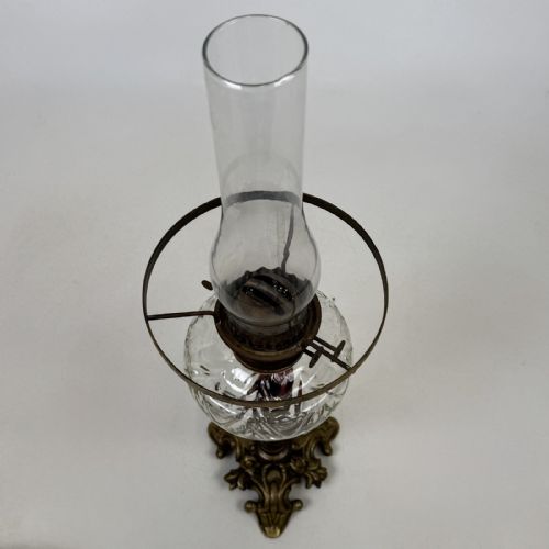 fig 4. A 19th-century brass oil lamp featuring a cast footed base, a spiral twisted column, a clear swirled glass reservoir, and a matching swirled glass shade.