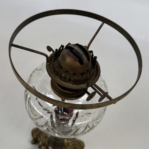 fig 5. A 19th-century brass oil lamp featuring a cast footed base, a spiral twisted column, a clear swirled glass reservoir, and a matching swirled glass shade.