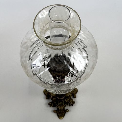 fig 6. A 19th-century brass oil lamp featuring a cast footed base, a spiral twisted column, a clear swirled glass reservoir, and a matching swirled glass shade.