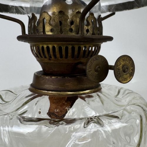 fig 7. A 19th-century brass oil lamp featuring a cast footed base, a spiral twisted column, a clear swirled glass reservoir, and a matching swirled glass shade.