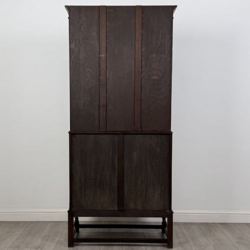 fig 5. A dark oak bureau bookcase with upper glazed doors, a fall-front desk flap, lower drawers, and turned barley twist legs.