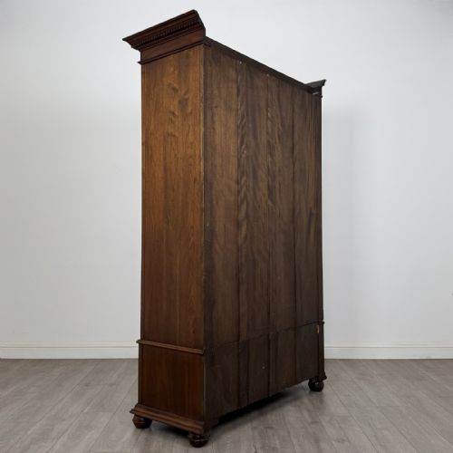 fig 3. An antique early 20th-century walnut double wardrobe featuring a full-length mirror door, panelled right door, geometric mouldings, and a single lower drawer.