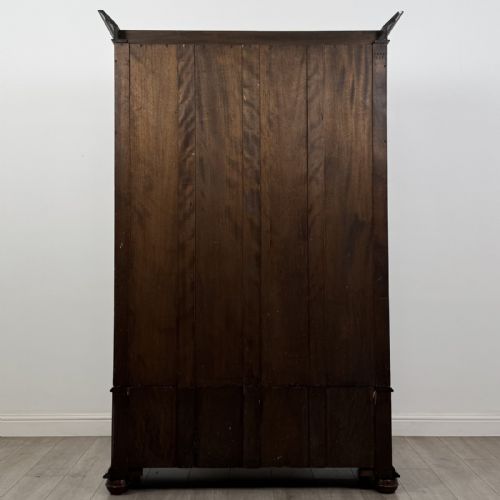 fig 4. An antique early 20th-century walnut double wardrobe featuring a full-length mirror door, panelled right door, geometric mouldings, and a single lower drawer.