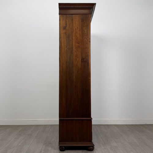 fig 6. An antique early 20th-century walnut double wardrobe featuring a full-length mirror door, panelled right door, geometric mouldings, and a single lower drawer.