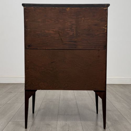 fig 4. An Edwardian dark mahogany bureau featuring a slant-front writing lid, a single drawer with brass drop handles, open lower compartment with arches, and tapered legs.