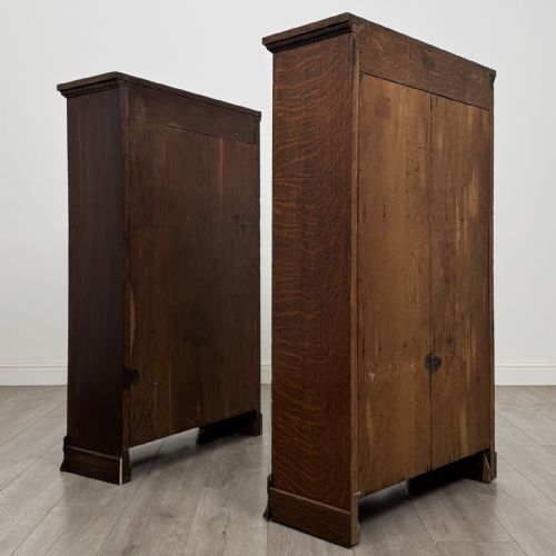 fig 6. A matching pair of dark oak Edwardian open bookcases featuring carved cornices, three shelves, and shaped plinth bases.