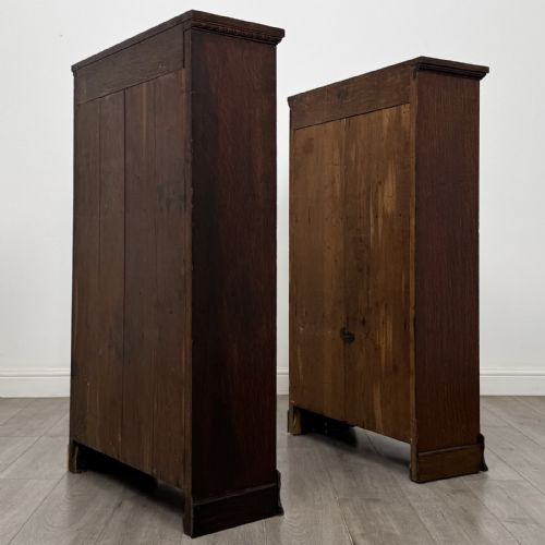 fig 8. A matching pair of dark oak Edwardian open bookcases featuring carved cornices, three shelves, and shaped plinth bases.
