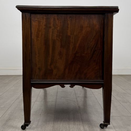 fig 3. An Edwardian inlaid mahogany sideboard with cherub marquetry panels, a central arched alcove, drawer, and square tapered legs with castors.