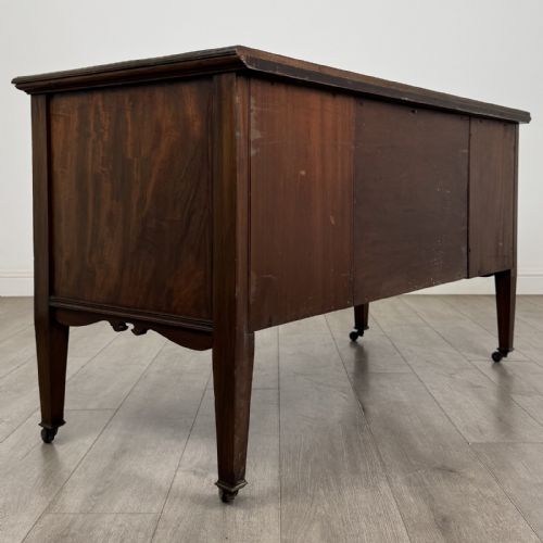 fig 4. An Edwardian inlaid mahogany sideboard with cherub marquetry panels, a central arched alcove, drawer, and square tapered legs with castors.