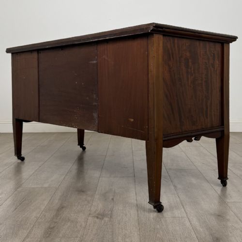fig 6. An Edwardian inlaid mahogany sideboard with cherub marquetry panels, a central arched alcove, drawer, and square tapered legs with castors.
