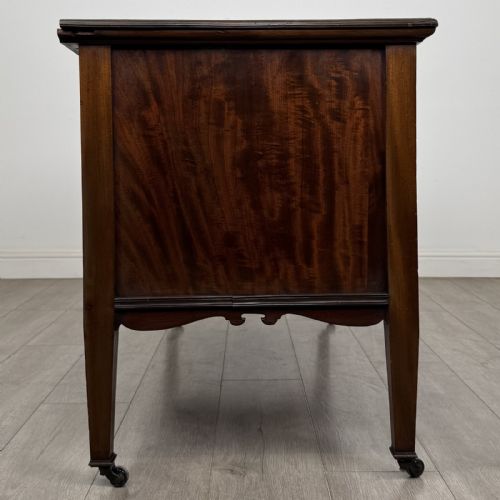 fig 7. An Edwardian inlaid mahogany sideboard with cherub marquetry panels, a central arched alcove, drawer, and square tapered legs with castors.