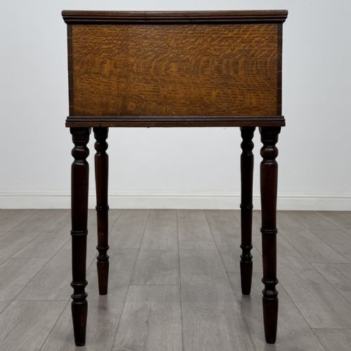 fig 5. A small dark oak Victorian clerks desk with a sloped hinged lid raised on tall turned legs.