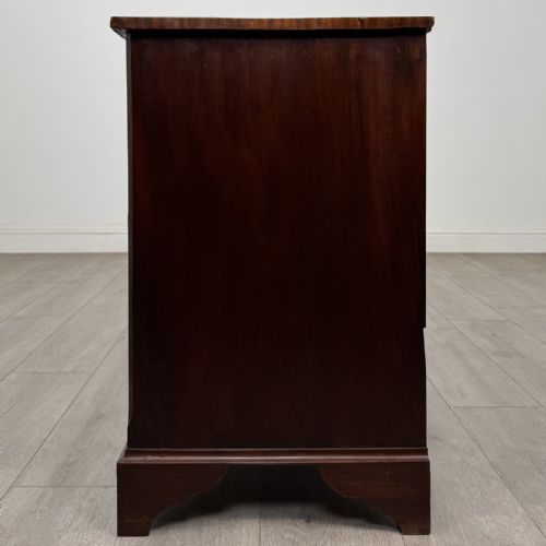 fig 2. A small Georgian-style dark mahogany chest of four drawers featuring brass ring pull handles and bracket feet.