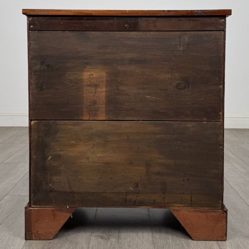 fig 4. A small Georgian-style dark mahogany chest of four drawers featuring brass ring pull handles and bracket feet.