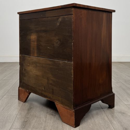 fig 5. A small Georgian-style dark mahogany chest of four drawers featuring brass ring pull handles and bracket feet.