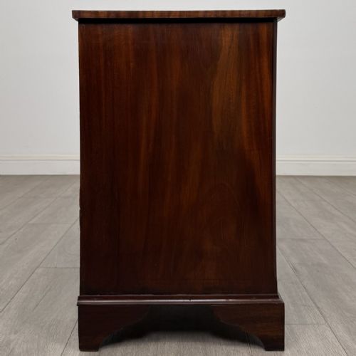 fig 6. A small Georgian-style dark mahogany chest of four drawers featuring brass ring pull handles and bracket feet.