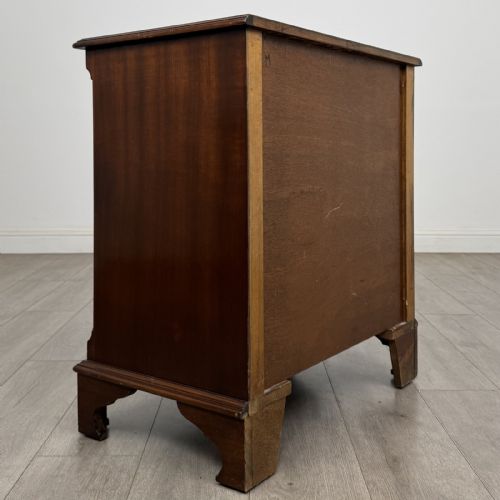 fig 3. A dark brown mahogany Georgian style chest of drawers featuring four drawers, fluted side pilasters, circular handles, and bracket feet.