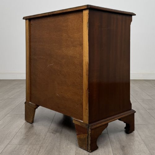 fig 5. A dark brown mahogany Georgian style chest of drawers featuring four drawers, fluted side pilasters, circular handles, and bracket feet.