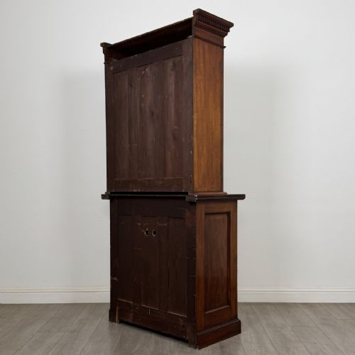 fig 5. A Victorian walnut glazed bookcase featuring a two-door glass display upper section above two drawers and a double cupboard base.
