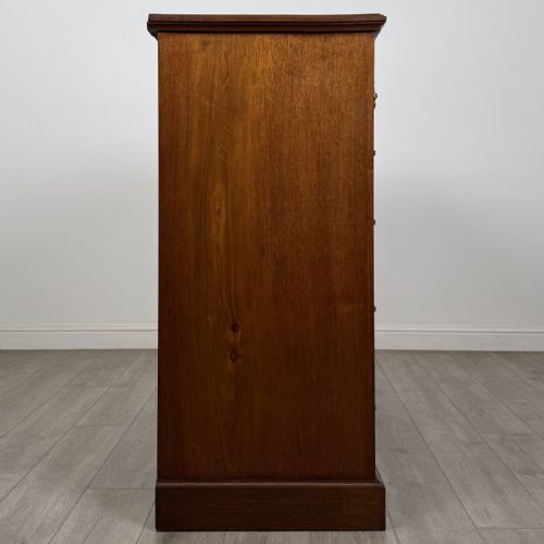 fig 6. A late Victorian walnut chest of drawers featuring a central square hat drawer flanked by smaller drawers above three long drawers with reeded moulding.