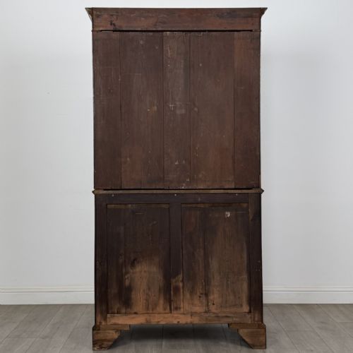 fig 4. An antique Georgian mahogany two-section bookcase featuring upper double doors with geometric astragal glazing over lower solid panelled cupboard doors, supported by bracket feet.