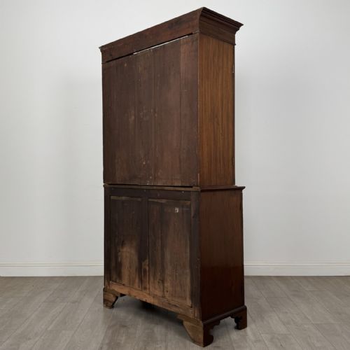 fig 5. An antique Georgian mahogany two-section bookcase featuring upper double doors with geometric astragal glazing over lower solid panelled cupboard doors, supported by bracket feet.