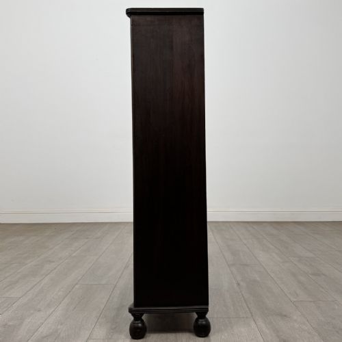 fig 2. A small dark wood open bookcase featuring three shelves, a carved lunette top frieze, reeded side columns, and turned ball feet.