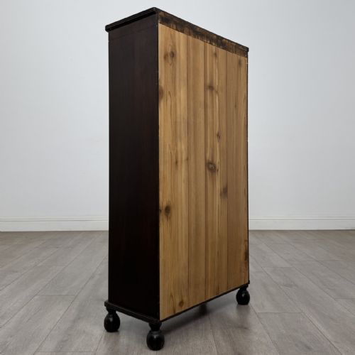 fig 3. A small dark wood open bookcase featuring three shelves, a carved lunette top frieze, reeded side columns, and turned ball feet.