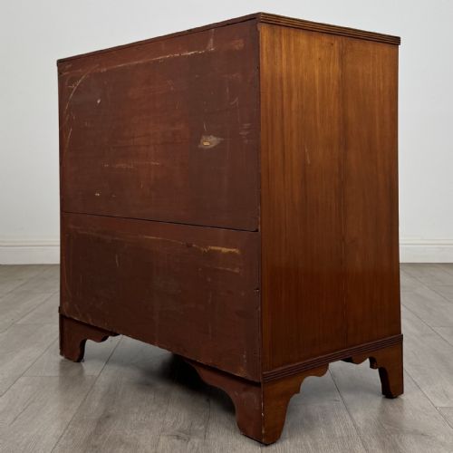 fig 5. A straight-front Georgian style mahogany chest features four full-width drawers with decorative oval brass drop handles, keyhole escutcheons, and bracket feet.