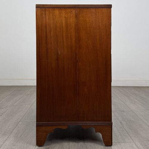 fig 6. A straight-front Georgian style mahogany chest features four full-width drawers with decorative oval brass drop handles, keyhole escutcheons, and bracket feet.