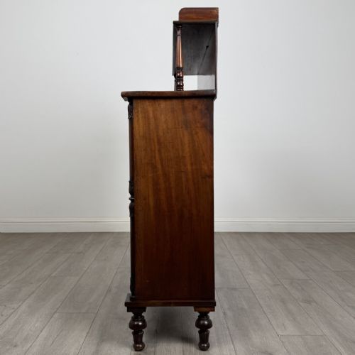 fig 3. A Regency mahogany chiffonier featuring a raised shelf, two drawers with brass ring handles, and a double-door cupboard flanked by carved columns on turned feet.