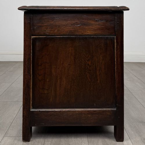 fig 2. A dark oak Jacobean style blanket box featuring a carved lunette frieze, three panelled sections, and guilloche carving along the stiles.