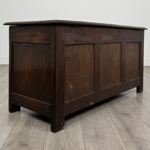 fig 3. A dark oak Jacobean style blanket box featuring a carved lunette frieze, three panelled sections, and guilloche carving along the stiles.