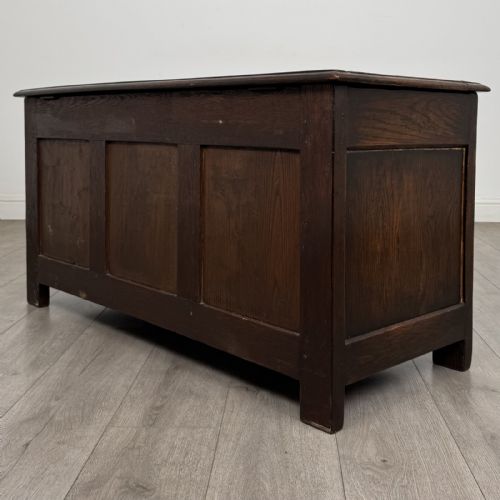 fig 5. A dark oak Jacobean style blanket box featuring a carved lunette frieze, three panelled sections, and guilloche carving along the stiles.