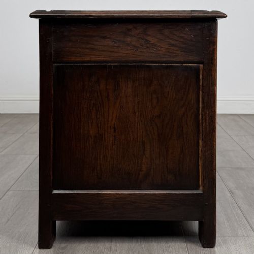 fig 6. A dark oak Jacobean style blanket box featuring a carved lunette frieze, three panelled sections, and guilloche carving along the stiles.