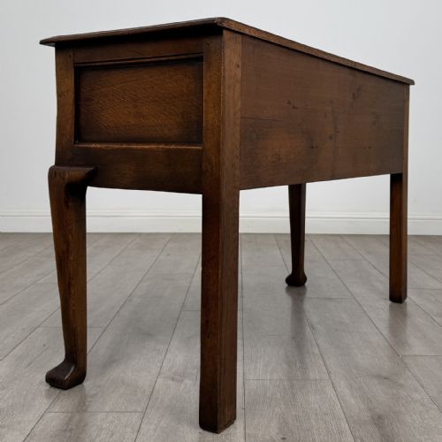 fig 3. A Georgian style dark oak dresser base featuring three drawers with brass swan-neck handles, a shaped apron, and cabriole front legs.
