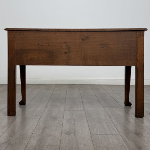 fig 4. A Georgian style dark oak dresser base featuring three drawers with brass swan-neck handles, a shaped apron, and cabriole front legs.