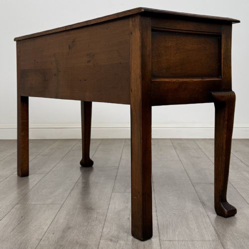 fig 5. A Georgian style dark oak dresser base featuring three drawers with brass swan-neck handles, a shaped apron, and cabriole front legs.