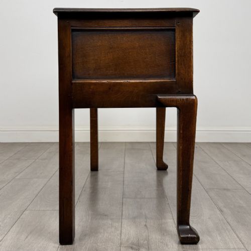 fig 6. A Georgian style dark oak dresser base featuring three drawers with brass swan-neck handles, a shaped apron, and cabriole front legs.
