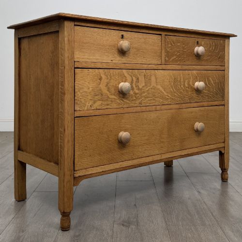 fig 7. An Edwardian quarter-sawn oak chest of drawers with two short drawers over two long drawers and turned wooden handles.