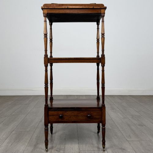 fig 1. An antique Regency rosewood three-tiered whatnot featuring an adjustable angled reading slope top, slender turned upright supports, a bottom drawer, and brass castors.