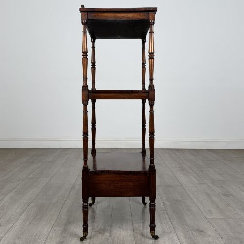 fig 4. An antique Regency rosewood three-tiered whatnot featuring an adjustable angled reading slope top, slender turned upright supports, a bottom drawer, and brass castors.