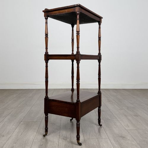 fig 5. An antique Regency rosewood three-tiered whatnot featuring an adjustable angled reading slope top, slender turned upright supports, a bottom drawer, and brass castors.