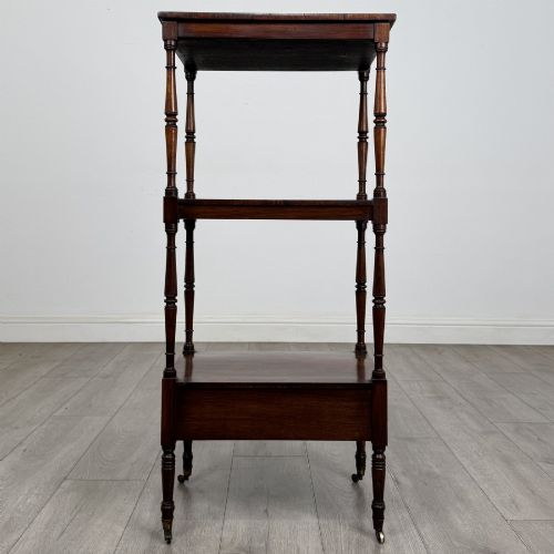 fig 6. An antique Regency rosewood three-tiered whatnot featuring an adjustable angled reading slope top, slender turned upright supports, a bottom drawer, and brass castors.
