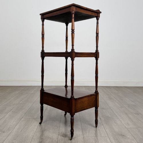 fig 7. An antique Regency rosewood three-tiered whatnot featuring an adjustable angled reading slope top, slender turned upright supports, a bottom drawer, and brass castors.