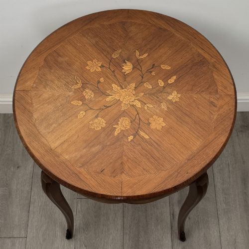 fig 6. A circular French Louis XV style lamp table featuring slender cabriole legs, marquetry wood grain pattern, an undulating apron, and metal sabot feet.