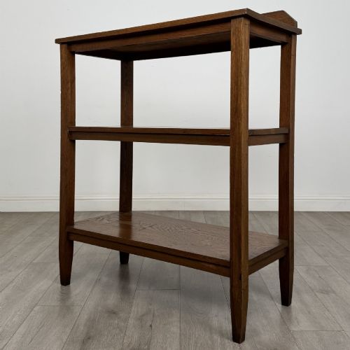 fig 1. An antique Edwardian dark oak buffet featuring three open rectangular shelves supported by straight tapered legs.