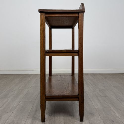 fig 2. An antique Edwardian dark oak buffet featuring three open rectangular shelves supported by straight tapered legs.